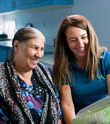 Caretaker wearing mask and gloves cleaning kitchen counter for Respite care service